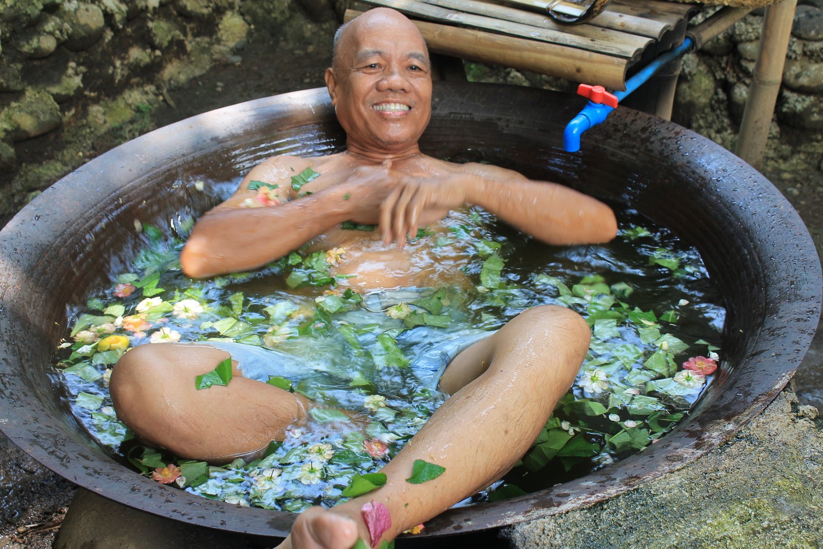 elder man enjoying turmeric bath in kawa for Misamis Occidental tourism guide