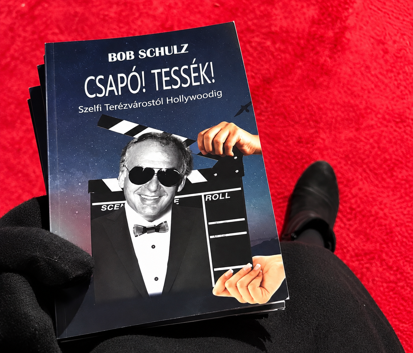 Bob Schulz’s autobiography, Csapó! Tessék!, featuring his portrait on the cover, photographed on a red carpet during his memorial tribute in Toronto.
