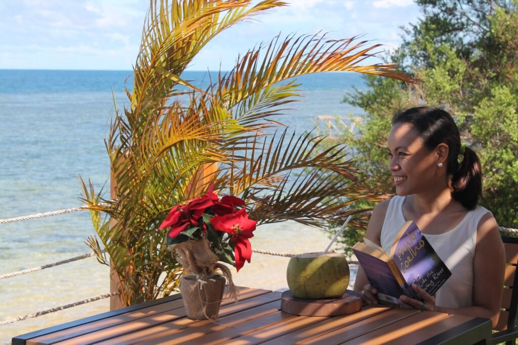 girl reading with coconut water in a beach in Misamis Occidental