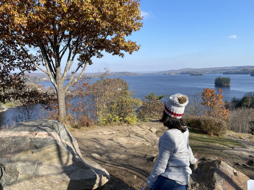 Woman overlooking a lake surrounded by autumn scenery in Ontario