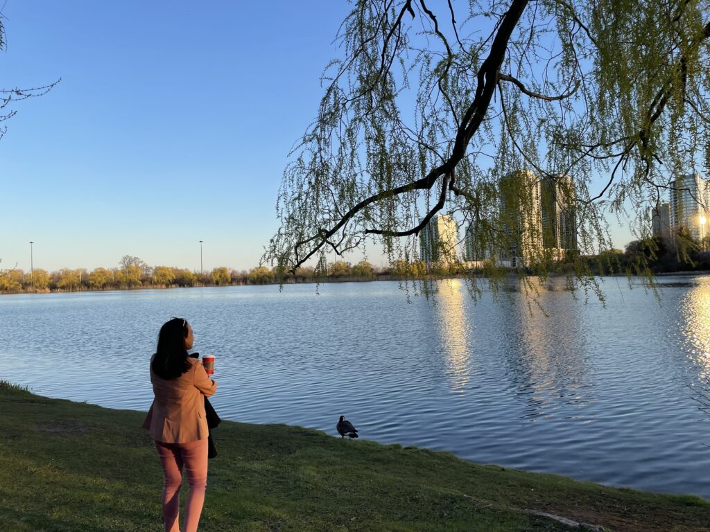 Woman standing quietly beside a lake at golden hour in Ontario
