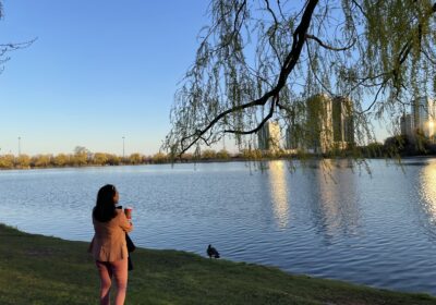 Woman standing quietly beside a lake at golden hour in Ontario